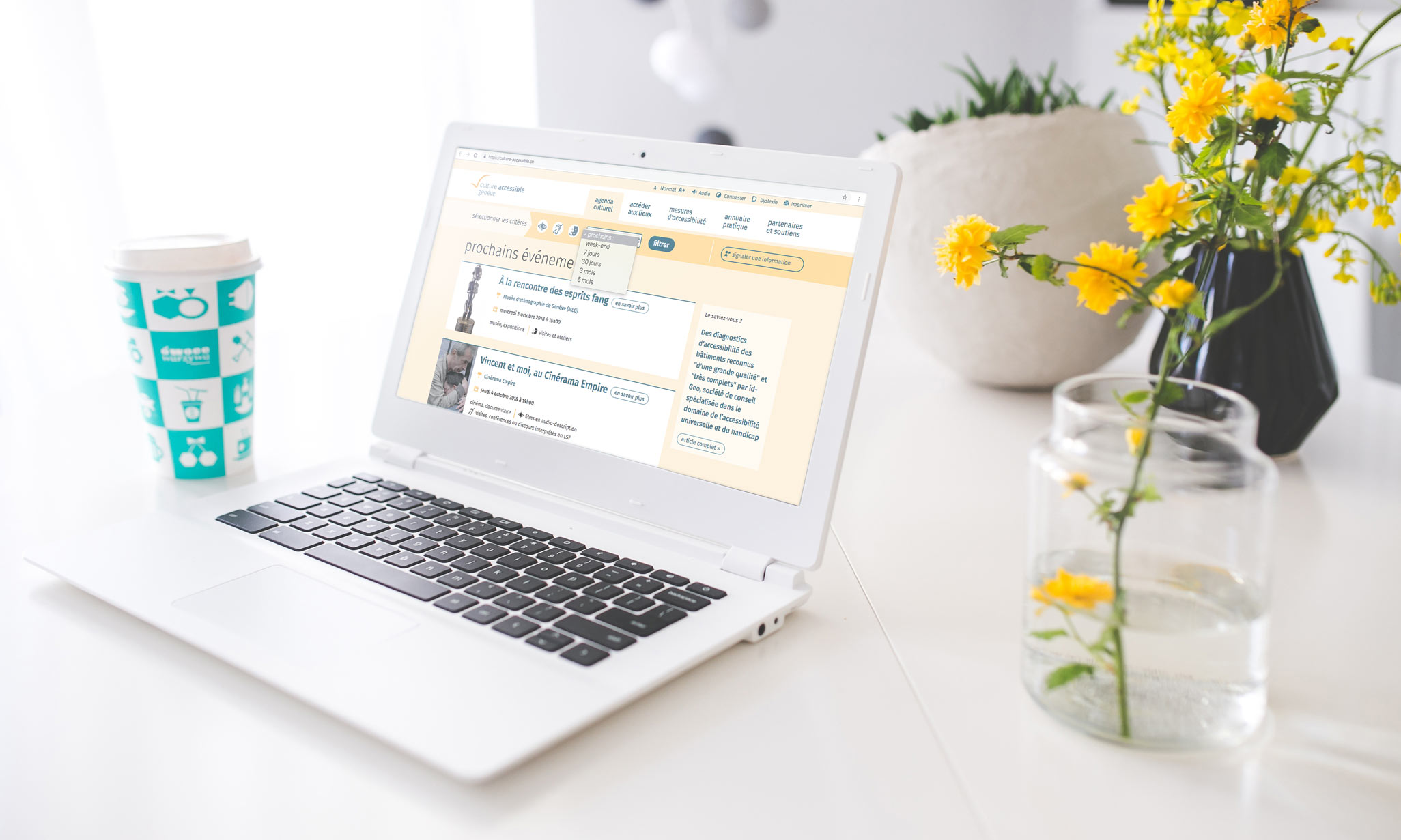 Ordinateur portable avec un pot de fleurs jaunes, présentant la page d'accueil du site culture-accessible.ch